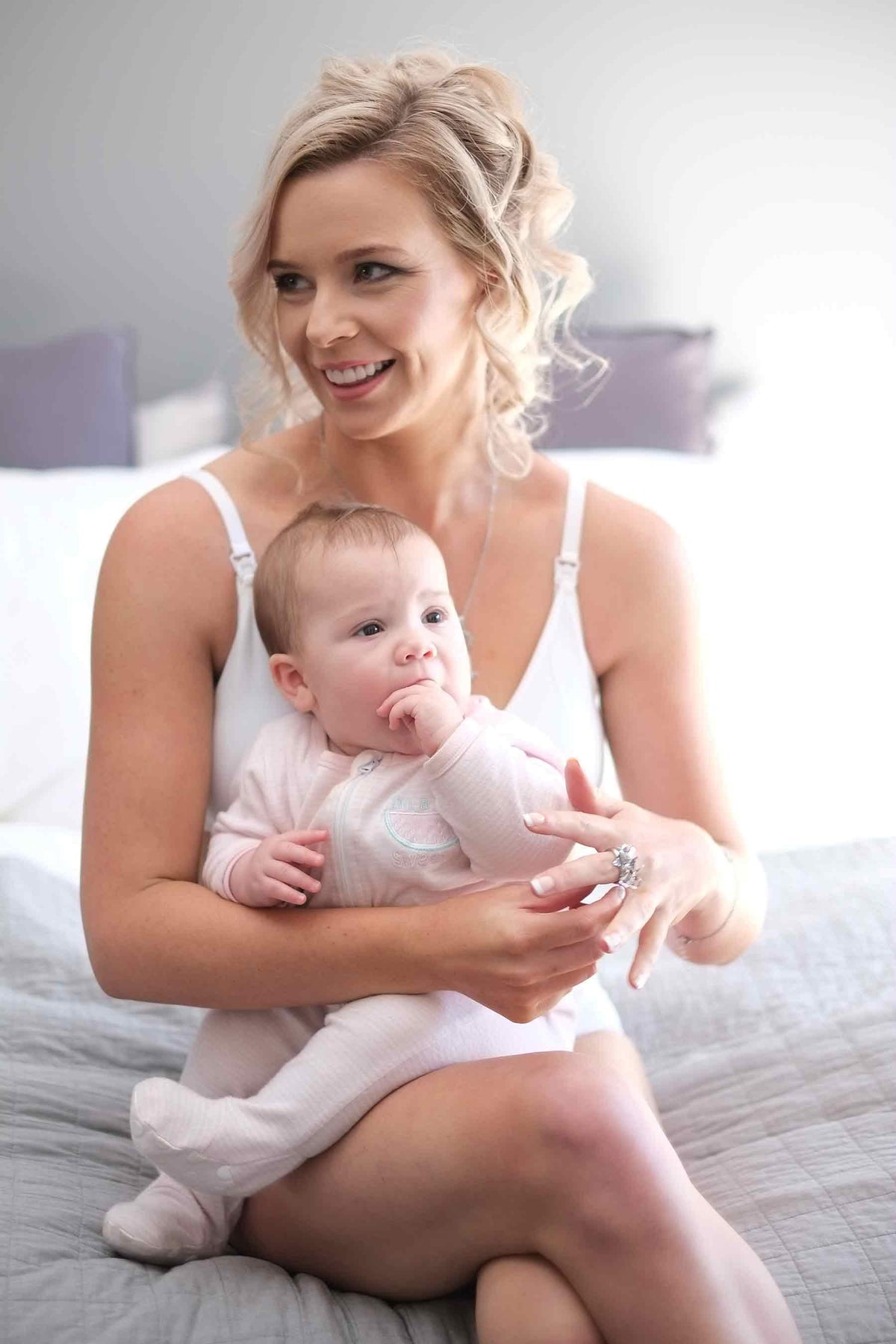 Woman holding a baby wears the white nursing bamboo camisole with built in bra - B Free Australia